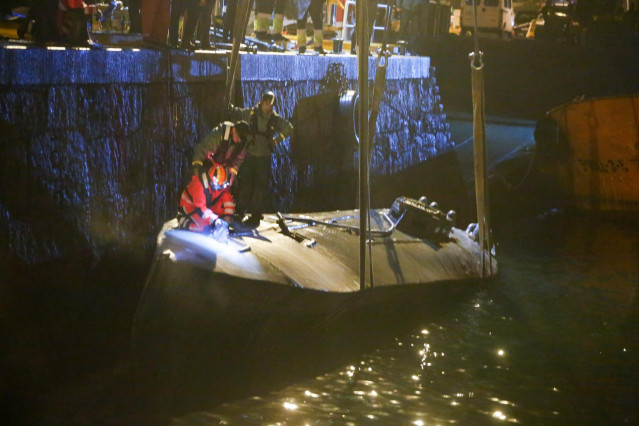 Agentes de la Policía y de la Guardia Civil subidos en el narcosubmarino hundido el pasado fin de semana a la entrada de la ría de Aldán, en Cangas (Pontevedra) en el momento en el que estaba siendo reflotado por dos grandes grúas. Se trata del primer nar