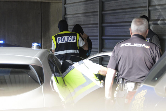 Archivo - Un agente lleva arrestado a uno de los acusados para declarar como presunto autor de la paliza que causó la muerte a Samuel Luiz en A Coruña el pasado 3 de julio.